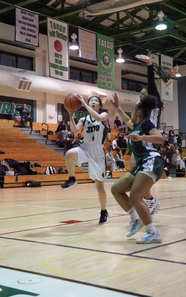 Junior Lily Lee (4) prepares for a smooth layup, her eyes locked on the basket as the defender closes in. With perfect timing, she powers through the pressure for an easy basket.